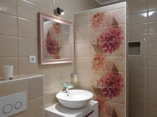 a bathroom with a sink and a wall with flowers at Apartments with parking space Povlja, Brac - 21089 in Povlja