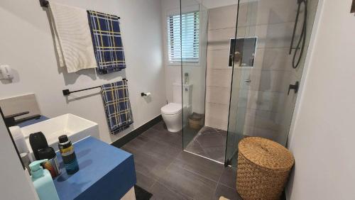 Un baño con ducha, inodoro y lavabo. en Bedarra Beachhouse, en South Mission Beach