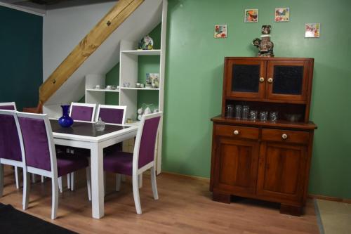 瓦爾迪維亞的住宿－CABAÑA 2 TINAJA-PISCINA-QUINCHO，一间带桌子和紫色椅子的用餐室