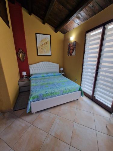 a bedroom with a bed and two windows at Al corso 3 in Naro