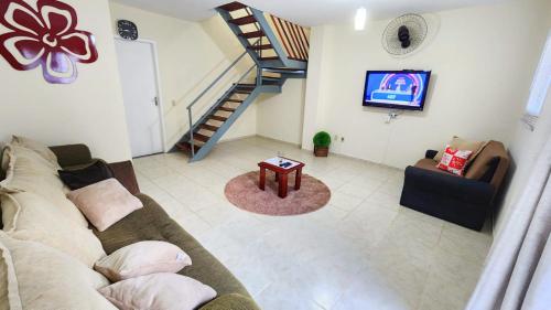 a living room with a couch and a staircase at casa da cris in Miguel Pereira