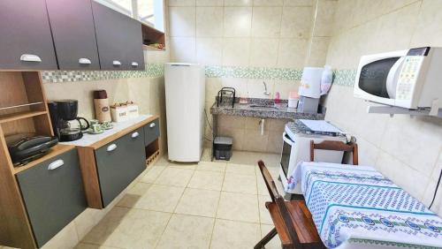 una pequeña cocina con mesa y microondas en casa da cris, en Miguel Pereira