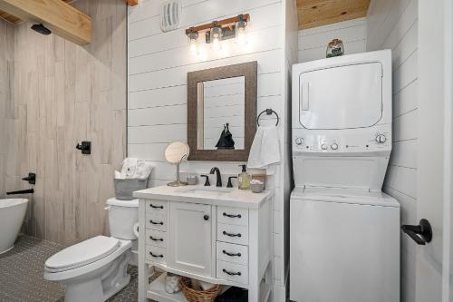 a white bathroom with a toilet and a sink at Whispering Pines - Lakeside in High Hill