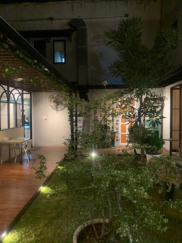 een huis met een tuin met bomen en verlichting bij RV Residence in Tebingtinggi