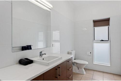 a white bathroom with a sink and a toilet at Discovery Parks - Alice Springs in Alice Springs