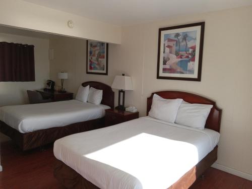 A bed or beds in a room at Blue Coast Inn & Suites