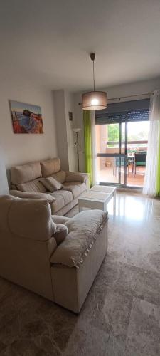 Sala de estar con 2 sofás, sofá y mesa en Cala Las Sirenas en Almería
