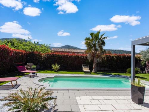 - une piscine avec 2 chaises et un palmier dans l'établissement Holiday Home near Côte d'Azur with Pool, à Gonfaron
