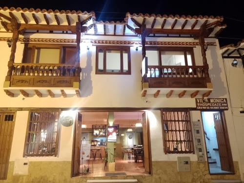 - un bâtiment avec 2 balcons et un coin repas dans l'établissement Hospedaje Villa Monica, à Villa de Leyva