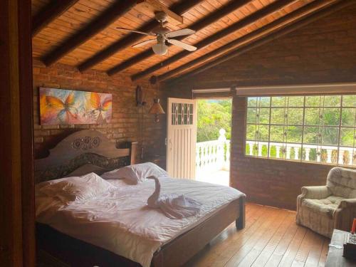 a bedroom with a bed and a ceiling fan at Hermosa Casa Campestre con Piscina y Jacuzzi in Silvania