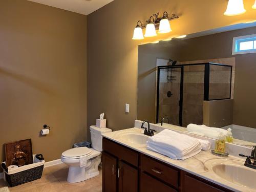 a bathroom with a sink and a toilet and a mirror at Five Stars Luxury Home in Clarksville