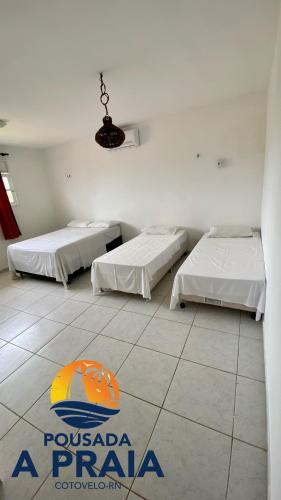 パルナミリンにあるPousada A Praiaのベッド2台が備わる客室で、床に看板があります。