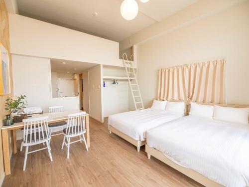 a bedroom with two beds and a desk and a ladder at Hotel Tomas Asahibashi Station in Naha