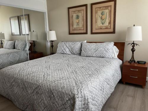 a bedroom with a bed and a large mirror at Turtle Bay Hale Lani Condo in Kahuku