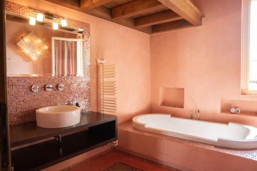 La grande salle de bains est pourvue d'une baignoire et d'un lavabo. dans l'établissement Terra Sole Aria Home Brescia, à Piazza
