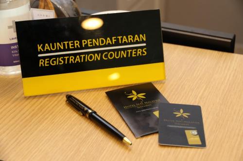 a pen sitting on top of a table with two passports at Hotel Seri Malaysia Seremban in Seremban