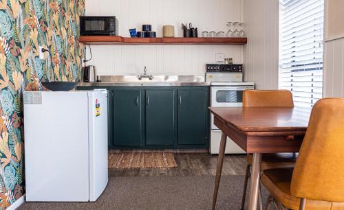 a kitchen with green cabinets and a white refrigerator at Clyde Central in Clyde