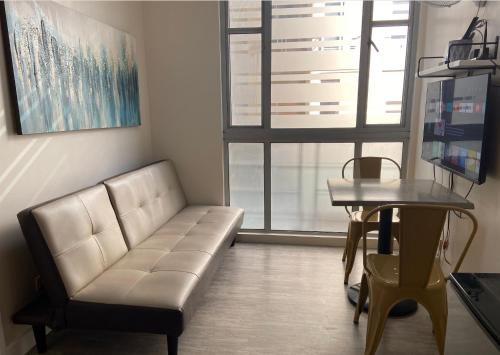 uma sala de estar com um sofá e uma mesa em Marikina Manila Condominium 1 Bedroom em Manilla