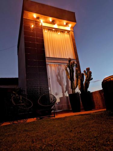 a house with lights on the side of it at Tiny House Paraiso Minicasas Com Hidromassagem in Pouso Alegre