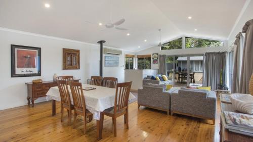 a dining room and living room with a table and chairs at Pippi Rikki - Pearl Beach With Wifi in Pearl Beach