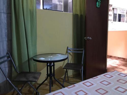 una mesa pequeña y 2 sillas en una habitación en Linda habitación de hotel en Trujillo, en Palomar