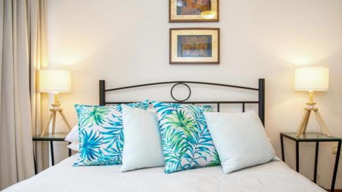 a bedroom with a bed with blue and white pillows at Hidden Treasure - Family Friendly Holiday Home in Pearl Beach