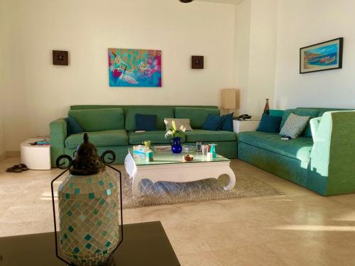 sala de estar con sofá verde y mesa de centro en Babel Apartment Qena en Qinā