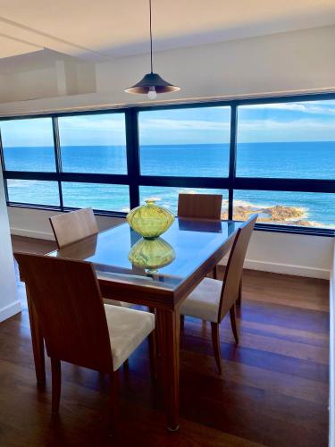 a dining room table with a view of the ocean at Ondina Apart Hotel Residences in Salvador