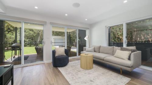 a living room with a couch and a table at Hop Skip and Jump To The Beach in Pearl Beach