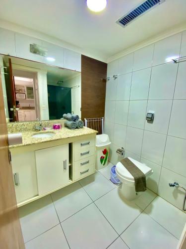 a bathroom with a toilet and a sink and a mirror at Ondina Apart Hotel Residences in Salvador