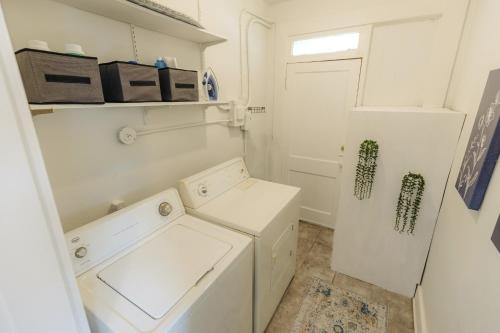a white laundry room with a washer and dryer at Historic Revival King Bed Midtown Memphis 66 Fast WiFi Free Parking Yes Pets in Memphis