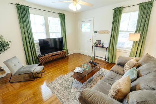 a living room with a couch and a flat screen tv at Historic Revival King Bed Midtown Memphis 66 Fast WiFi Free Parking Yes Pets in Memphis