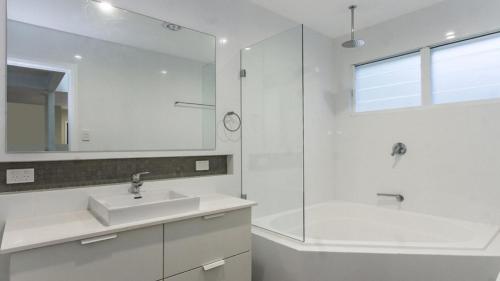 a white bathroom with a sink and a shower at Luxury Escape On Crystal in Pearl Beach