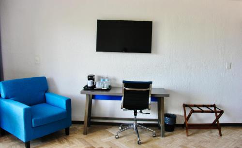 een kamer met een bureau, een stoel en een televisie bij BOK21 - Hotel en Cancun in Cancun