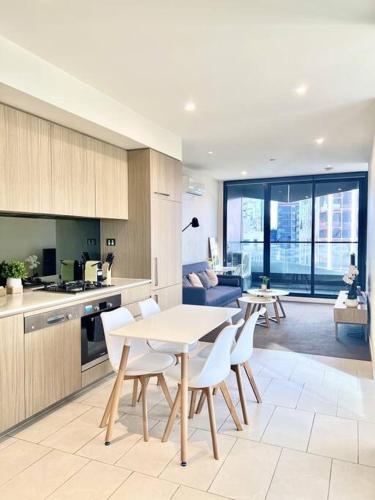 a kitchen and living room with a table and chairs at Stunning 2-Bed Apartment with Panoramic CBD Views in Melbourne