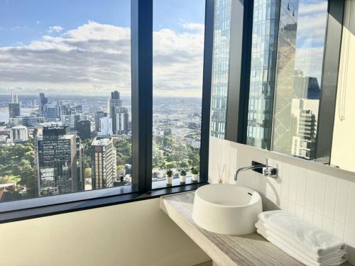 メルボルンにあるStunning 2-Bed Apartment with Panoramic CBD Viewsのバスルーム(シンク付)が備わり、市街の景色を望めます。