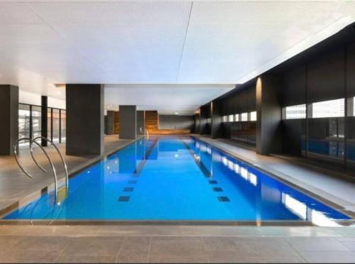 メルボルンにあるStunning 2-Bed Apartment with Panoramic CBD Viewsの建物内の青い水の大きなプール
