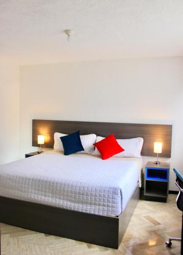 a bedroom with a large bed with red and blue pillows at BOK21 - Hotel en Cancun in Cancún