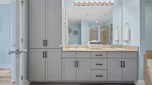 a bathroom with two sinks and a large mirror at Some Beach Some Where at Laketown Wharf #825 by Nautical Properties in Panama City Beach