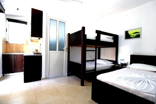 a bedroom with two bunk beds and a kitchen at Vila Reni Risi in Ksamil