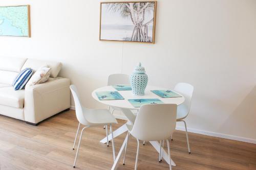 een eetkamer met een witte tafel en stoelen bij Shingley Beach Resort - Whitsundays in Airlie Beach