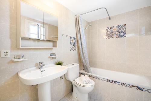 a bathroom with a sink and a toilet and a tub at Can Poriol in Alaior