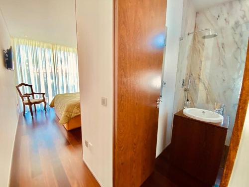 um quarto com uma casa de banho com um lavatório e uma cama em Portugal Holidays Villa - HOUSE CAR FOR GUEST USE INCLUDED IN THE DAILY RATE em Barcelos
