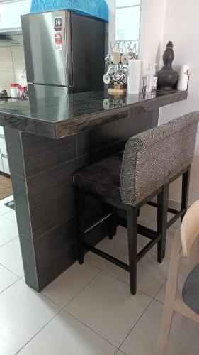 a kitchen counter with a refrigerator and a chair at Rosnah Homestay in Kampong Ayer Resam