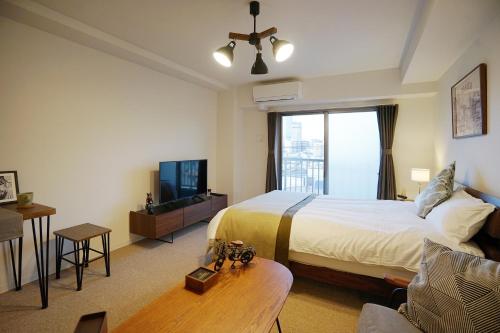 a hotel room with a bed and a tv at Chuan House Nambaminami Hanazonocho in Osaka