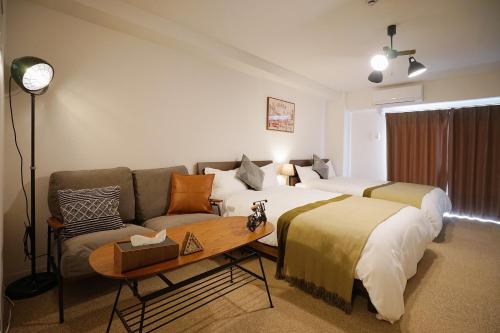a hotel room with a bed and a couch at Chuan House Nambaminami Hanazonocho in Osaka