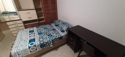 a bedroom with a bed and a dresser in a room at Casa Hostal Aromas. Habitación acomodacion multiple in Bucaramanga