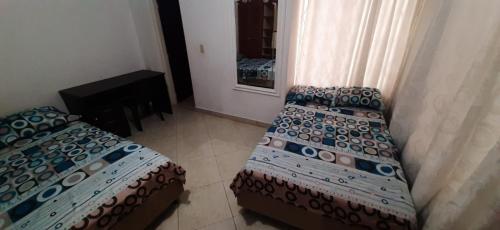 a bedroom with a bed and a couch and a mirror at Casa Hostal Aromas. Habitación acomodacion multiple in Bucaramanga