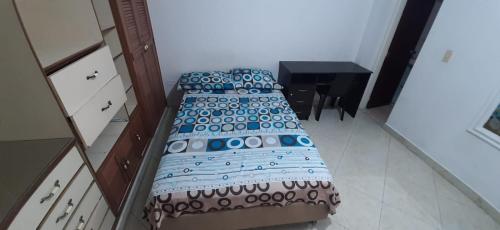two twin beds in a room with a table at Casa Hostal Aromas. Habitación acomodacion multiple in Bucaramanga
