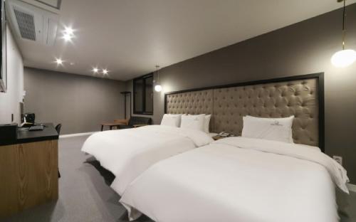 a bedroom with two large beds with white sheets at Forest 701 hotel in Changwon